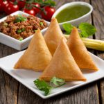 Sweet, tasty, fried indian dish samosha.Indian Delicious Deep Fried Breakfast Samosa Also Know as Samoosa isolated on Wooden texture Background